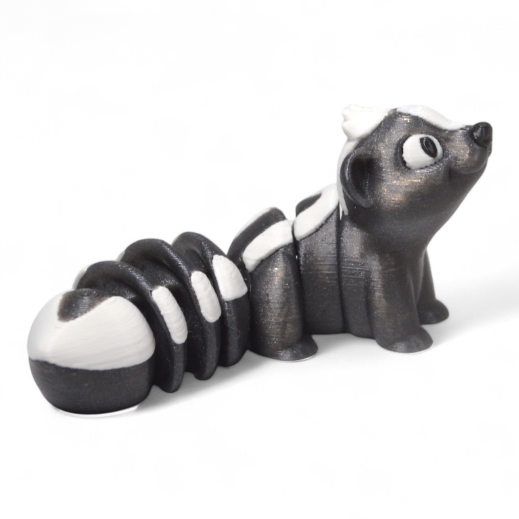 Yan açıdan Cribbliz kokarca figürü – uzun kuyruğu ve siyah beyaz renkleriyle dikkat çeken oyuncak